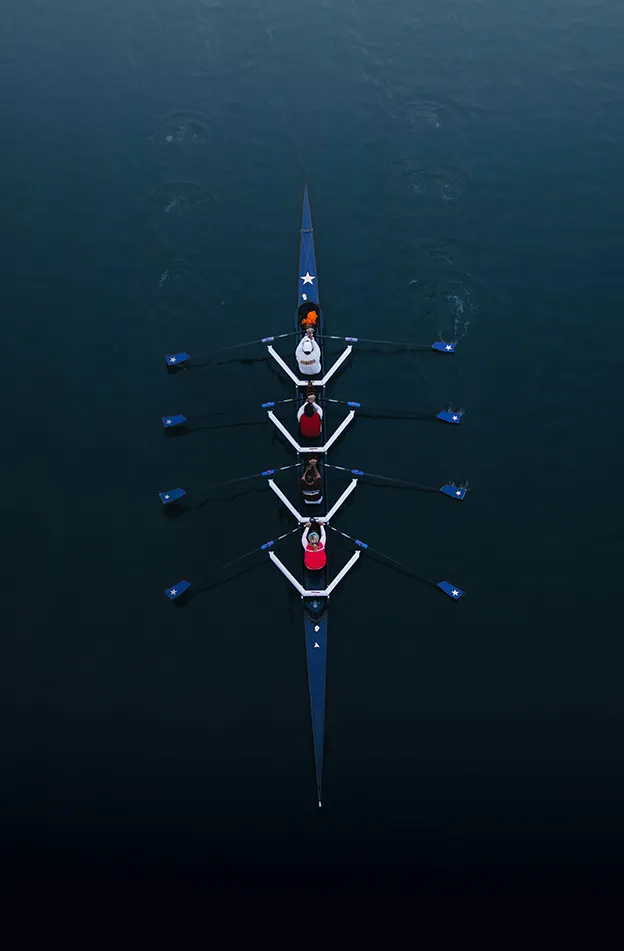 Four people rowing in a rowing boat (portrait)
